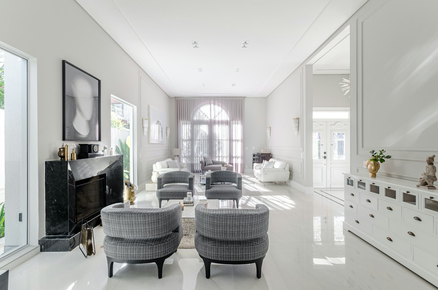 Modern living room with plaid armchairs and a marble fireplace.