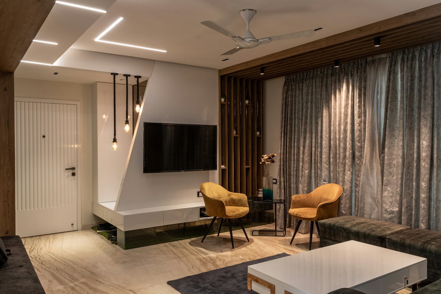Modern living room with yellow armchairs and a grey sofa.