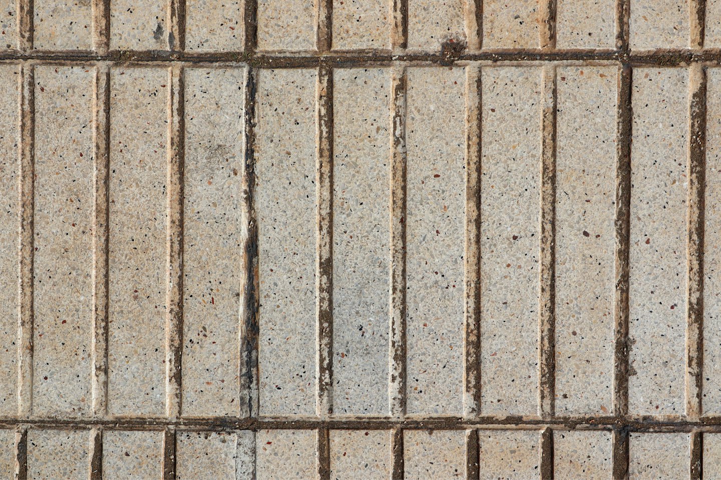 Grey concrete pavement with dark brown grooves.